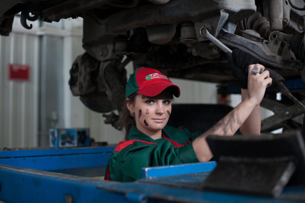 Woman Holding Gray Steel Wrench performing car maintenance