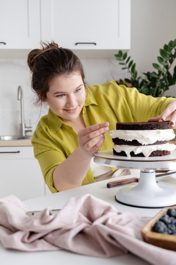Smiling woman cooking cake in kitchen which reminds us to follow your passion