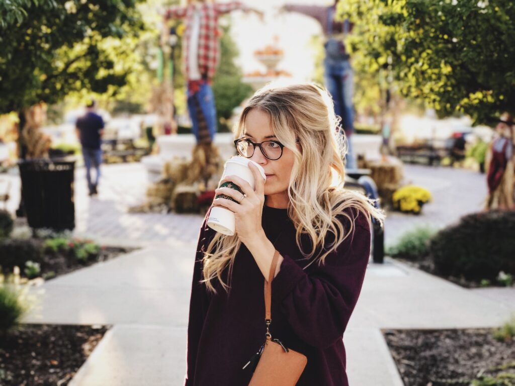 woman drinking latte out of a white cup