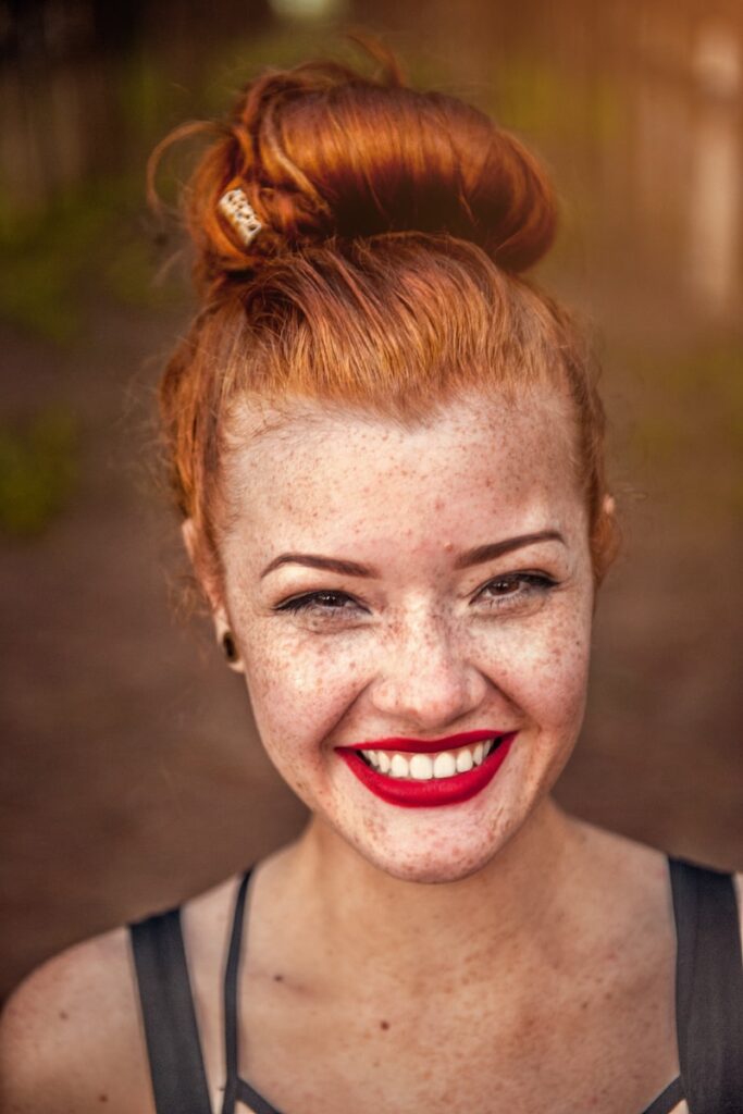 woman taking photo while showing smile for an article with things to naturally whiten teeth