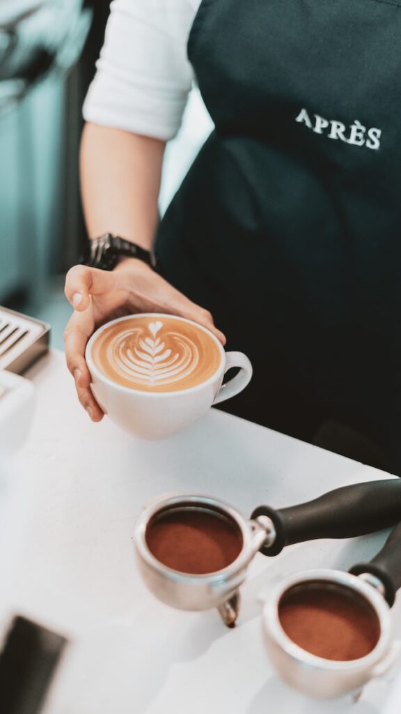 person pouring coffee on white ceramic cup